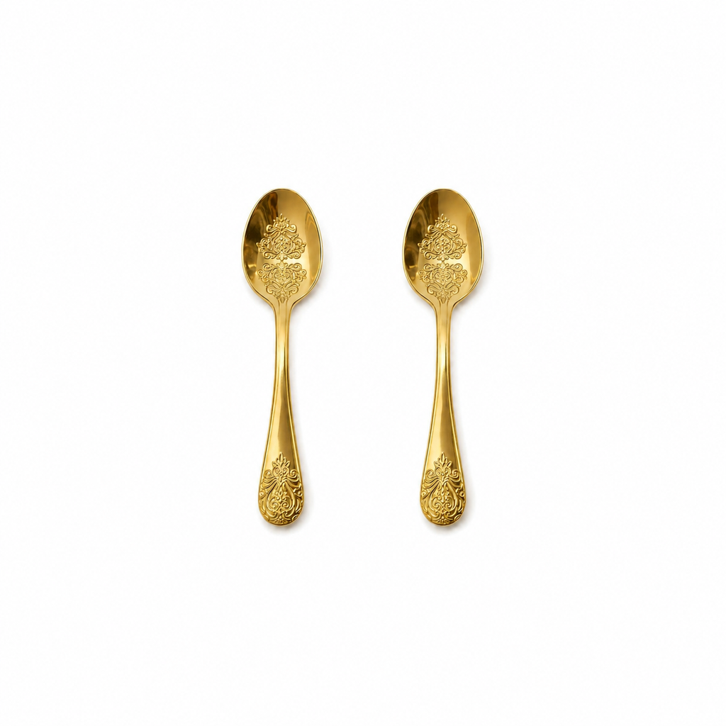 Twee kleine gouden theelepels van 10 cm op witte achtergrond