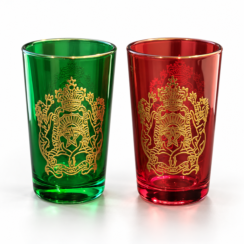 Detail van het goudkleurige embleem op rode en groene theeglazen