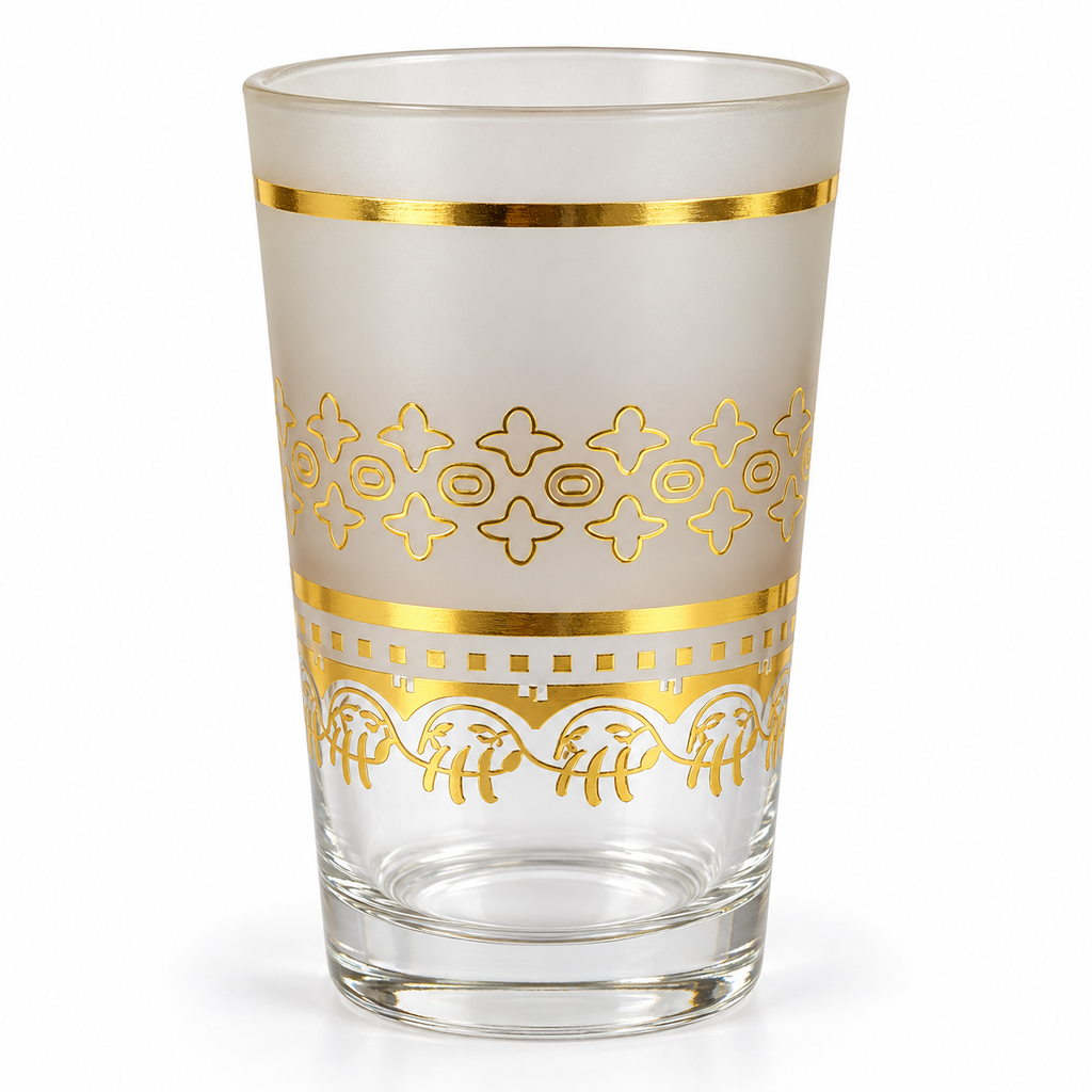 Detail van een mat theeglas met gouden versiering en transparante voet