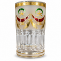 Detail van een Marokkaans theeglas met gouden band, rood-groen motief en geribbelde onderzijde